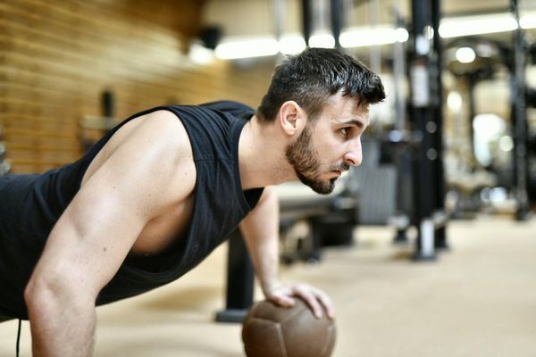 Man performing a controlled bodyweight exercise with intense focus.